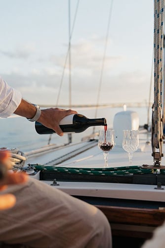 Hand pouring a drink on a boat (alternate)